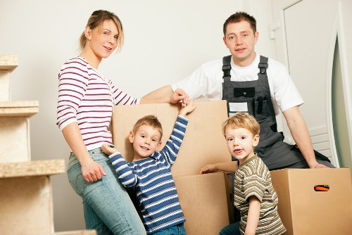 Movers carrying furniture through a Surrey property during a house relocation
